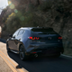 A photo fo a grey Mazda 3 Hatchback driving on a road.